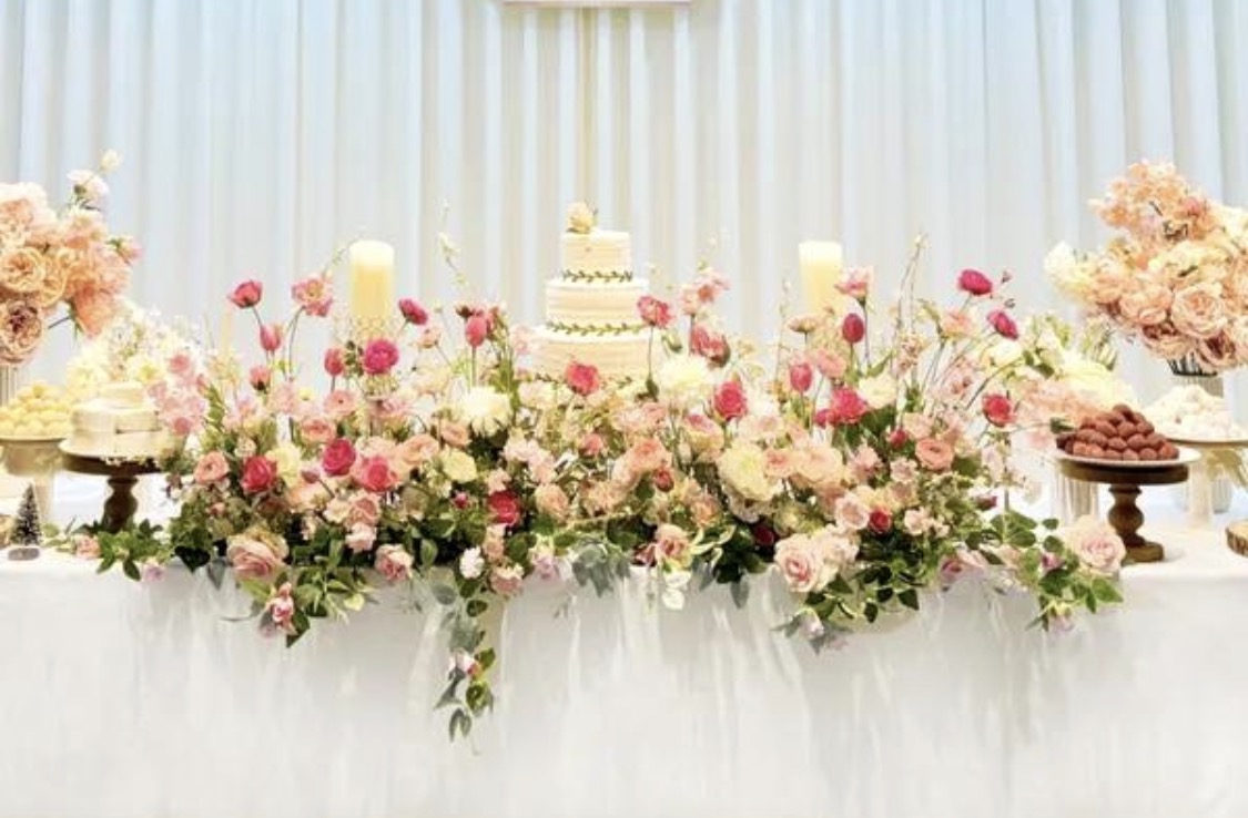 Lush head table floral runner with tiered cake